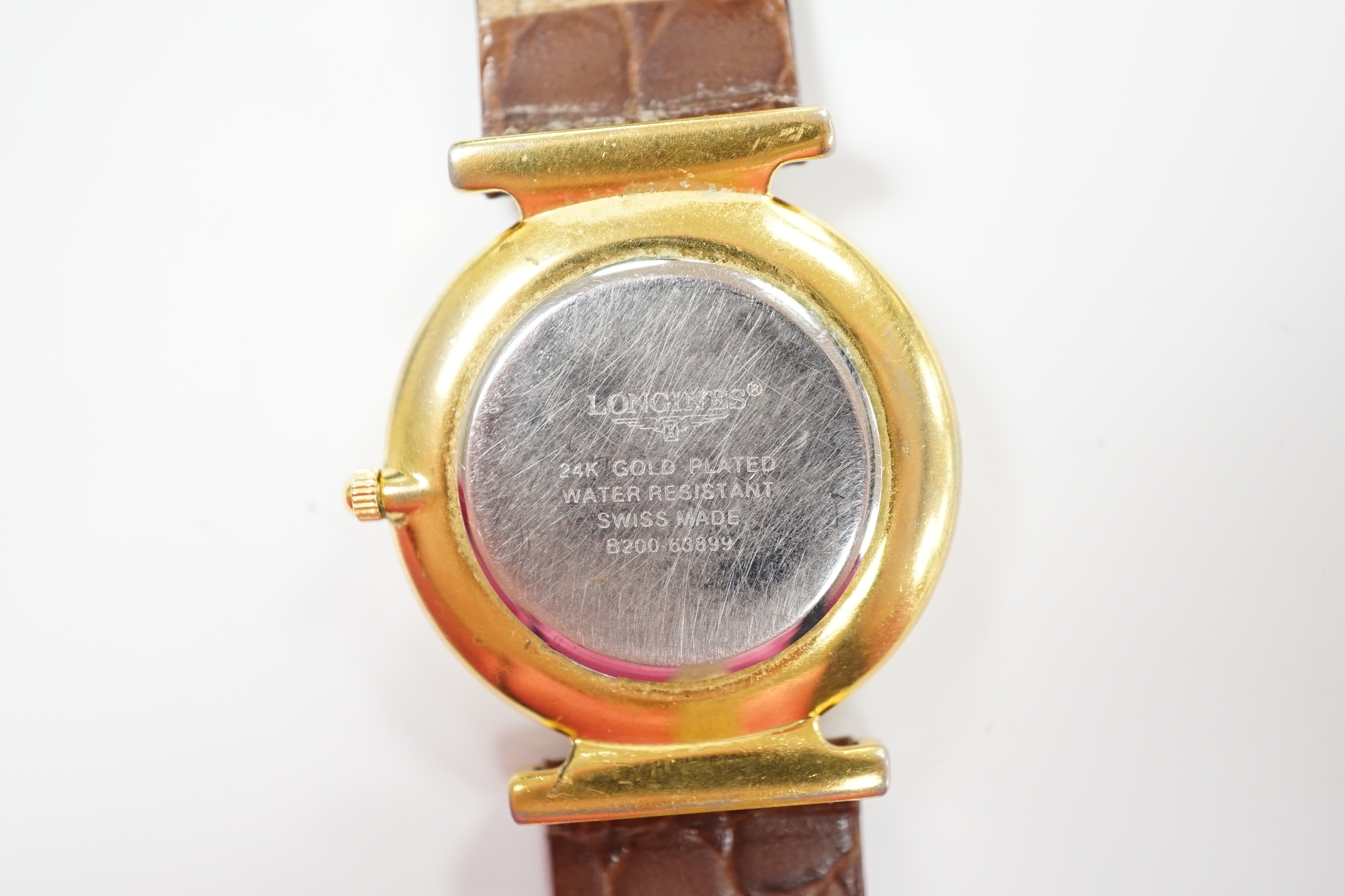A gentleman's 24kt gold plated Longines quartz dress wrist watch, on associated leather strap.